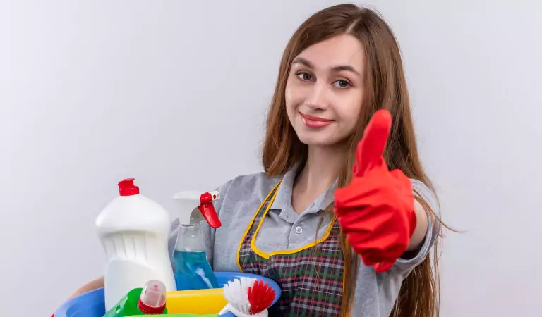 young woman with a basket full of cleaning supplies