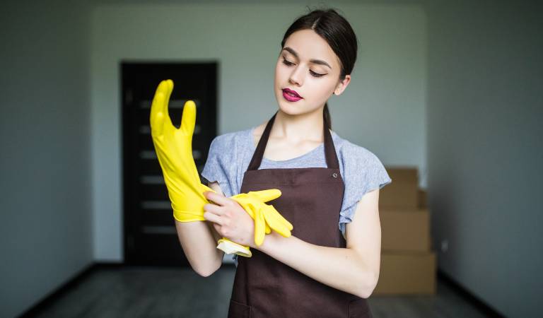 Woman is wearing gloves and planning to clean her home