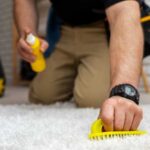 Professional cleaner is cleaning carpet using a spray