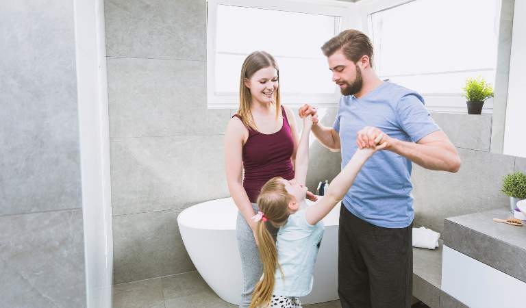 Man and woman with a kid seeing happy inside a new bathroom