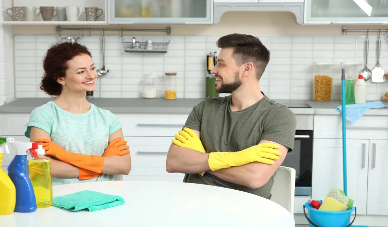 Happy young couple cleaning kitchen together