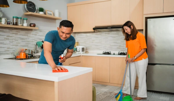Asian couple cleaning their kitchen together household chores concept