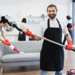 Portrait of bearded cleaner from cleaning service holding vacuum cleaner