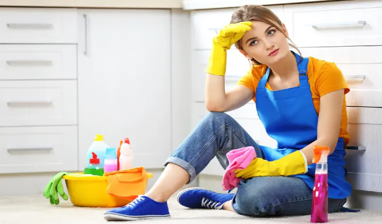 Cleaning concept young woman sitting on the floor with cleaning fluids