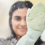 A little soap is all we need. Shot of a young woman washing windows at home.