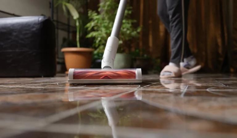 Cordless vacuum cleaner with turbo brush cleans tiles in living room