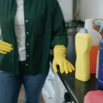 Woman in kitchen with the cleaning products
