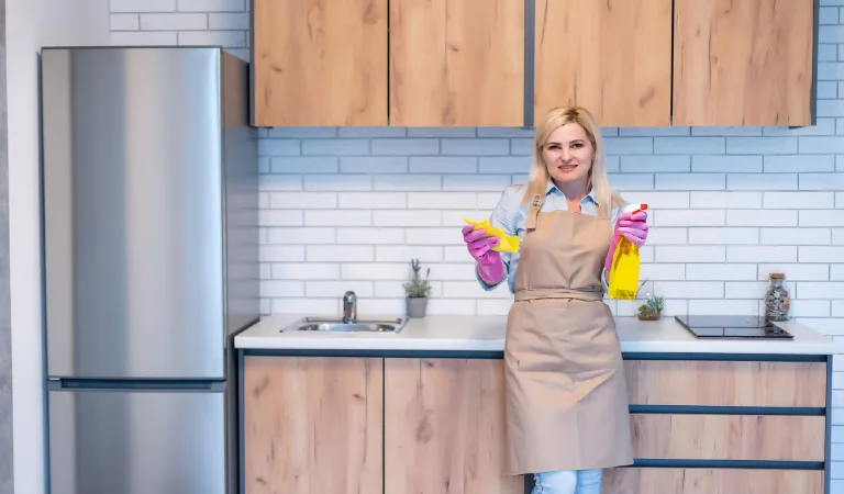 Young woman cleaning kitchen cabinets